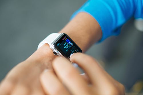person wearing silver Apple Watch with white Sport Band